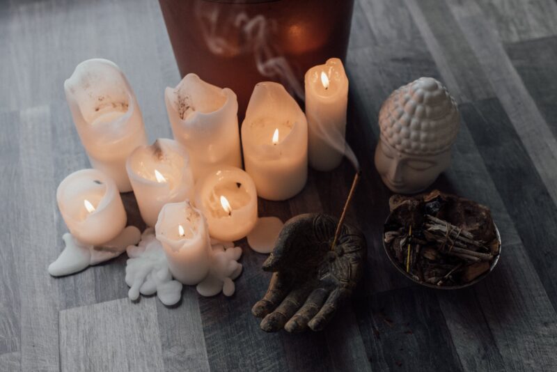 lighted candles beside an incense