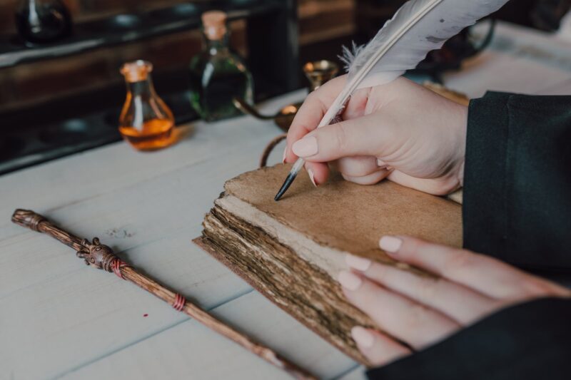 close up shot of a person writing on a spell book