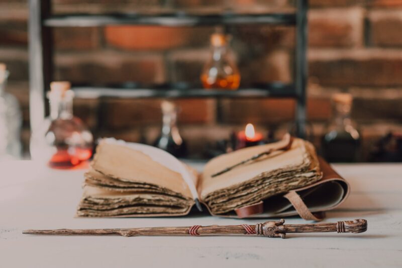 close up shot of a wand beside a spell book