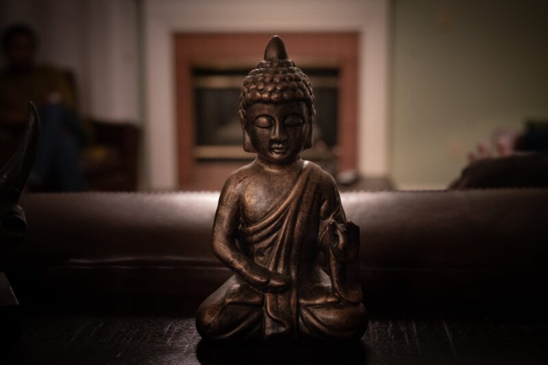 brass buddha figurine on black surface